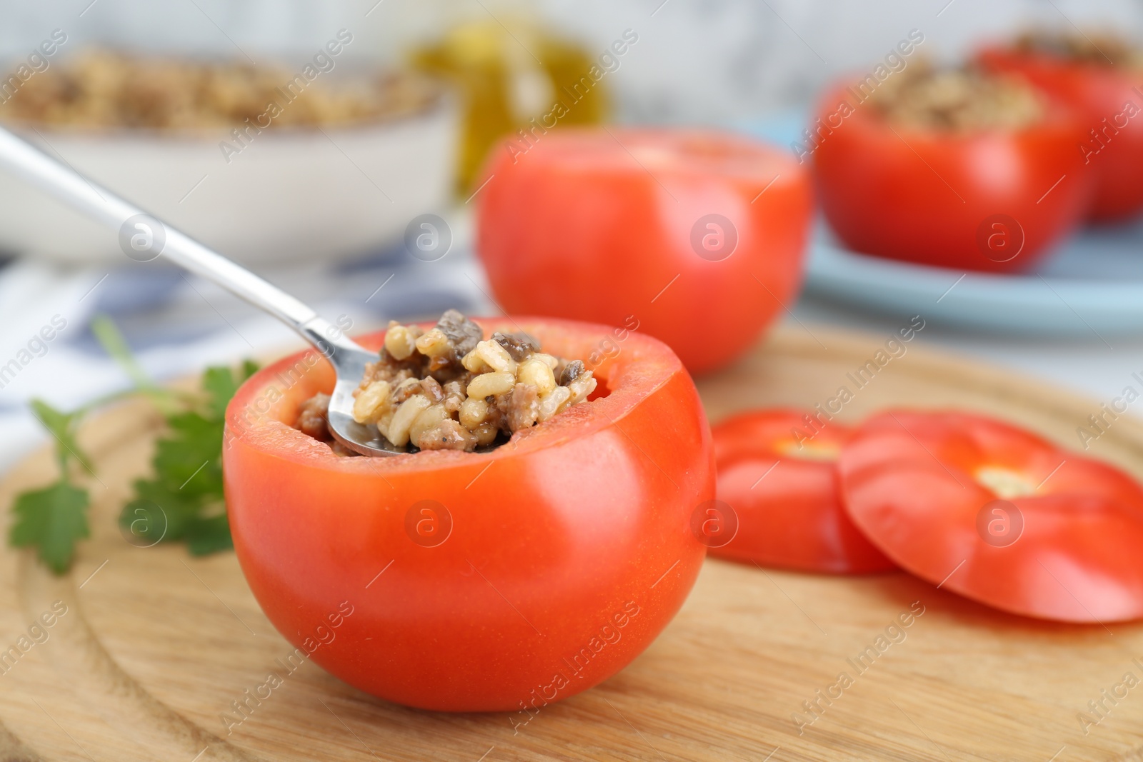 Photo of Preparing stuffed tomato with minced beef, bulgur and mushrooms on wooden board, closeup