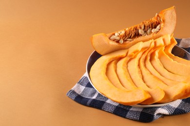 Photo of Slices of fresh ripe pumpkin on orange background, space for text