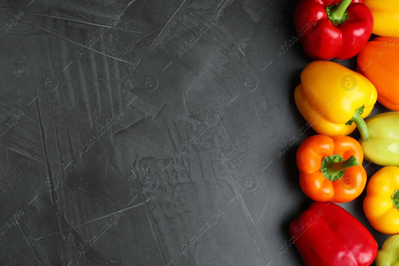 Photo of Fresh ripe bell peppers on grey table, top view. Space for text