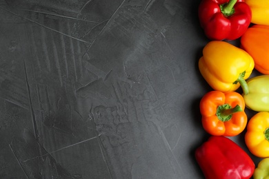 Photo of Fresh ripe bell peppers on grey table, top view. Space for text