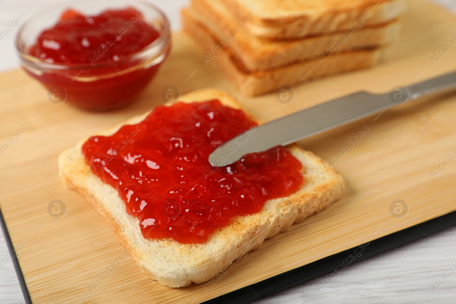 Photo of Fresh toast with delicious blueberry jam on white wooden table, closeup