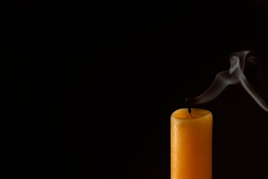 Photo of Church extinguished candle on dark background, closeup. Space for text