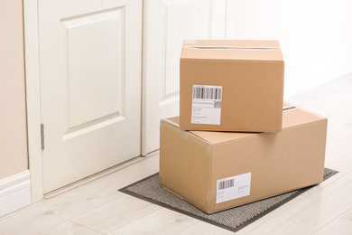 Photo of Parcels on rug near door. Delivery service