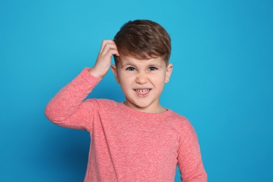 Photo of Little boy scratching head on color background. Annoying itch