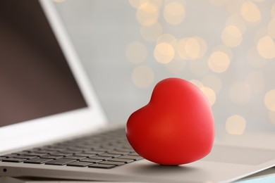 Red decorative heart on laptop, closeup. Online dating