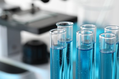 Test tubes with light blue liquid in laboratory, closeup