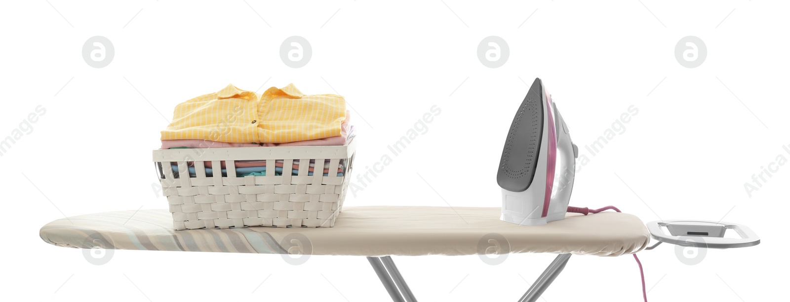 Photo of Board with modern iron and laundry basket on white background