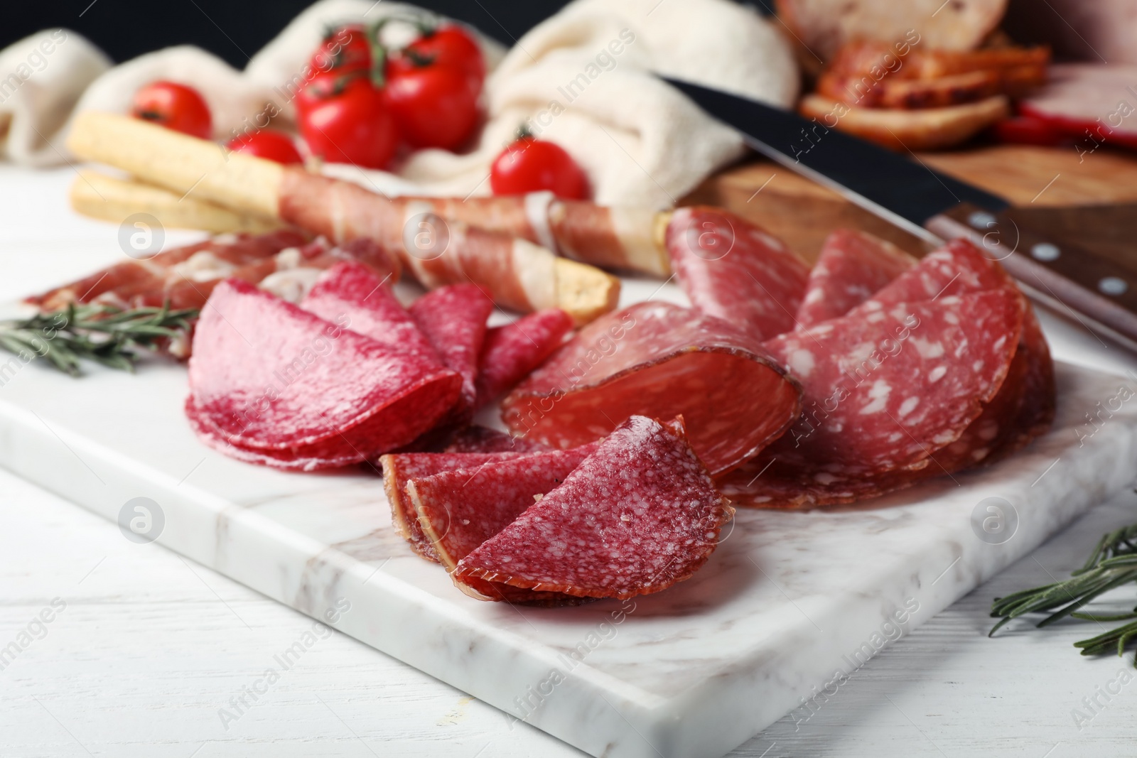 Photo of Cutting board with different sliced meat products served on table