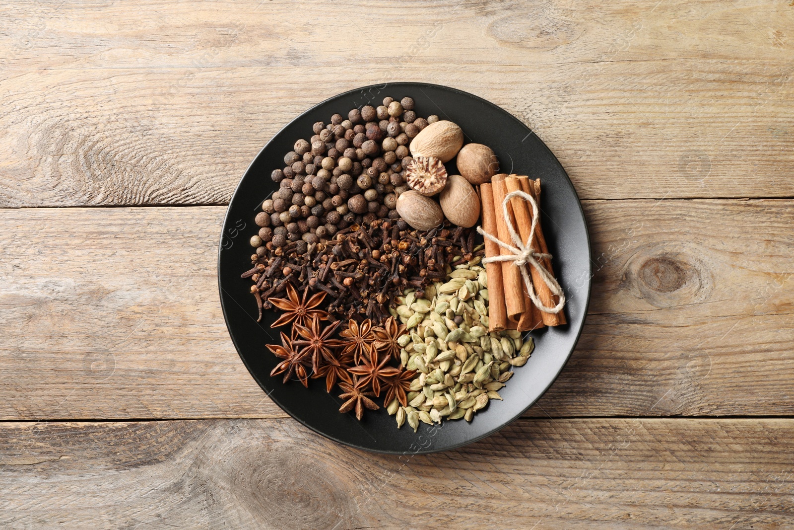 Photo of Different spices and nuts on wooden table, top view