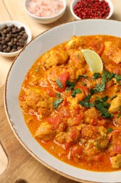 Photo of Delicious chicken curry and spices on table