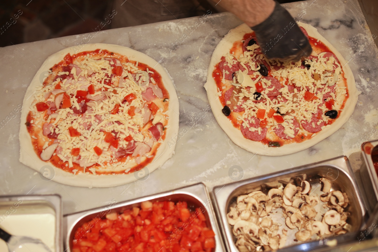 Photo of Man making pizzas at table, view from above