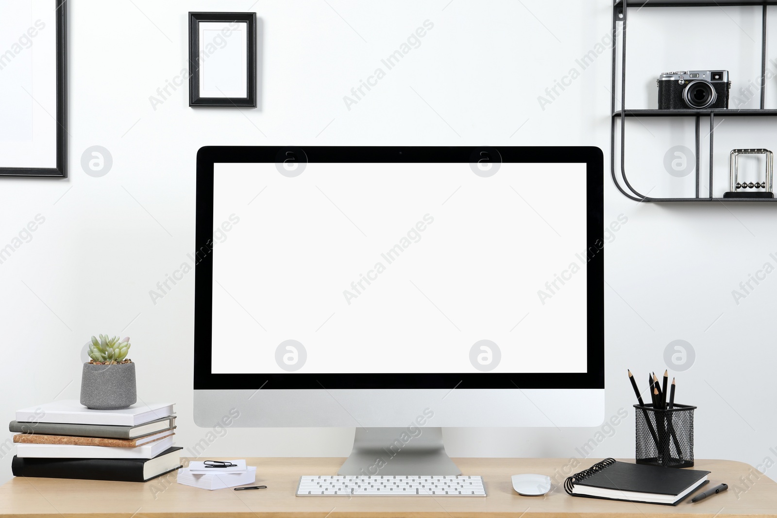 Photo of Cozy workspace with computer and stationery on wooden desk at home