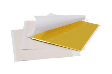 Many edible gold leaf sheets on white background