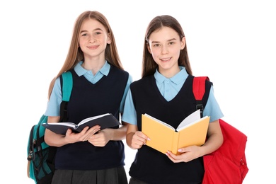 Photo of Portrait of teenage girls in school uniform with backpacks and books on white background