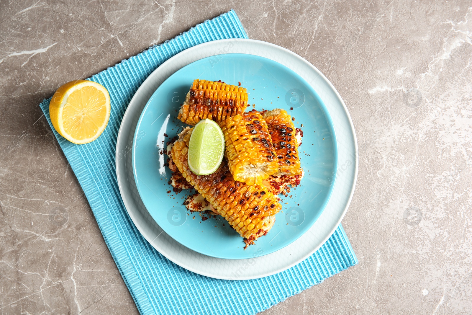 Photo of Plate with delicious grilled corn cobs and spices on table, top view