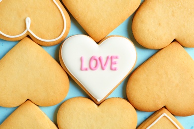 Photo of Decorated heart shaped cookies on color background, top view. Valentine's day treat