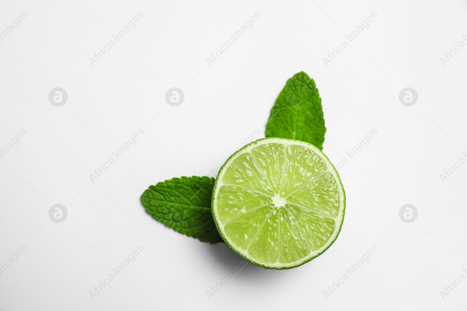 Photo of Cut fresh juicy lime and mint on white background, top view