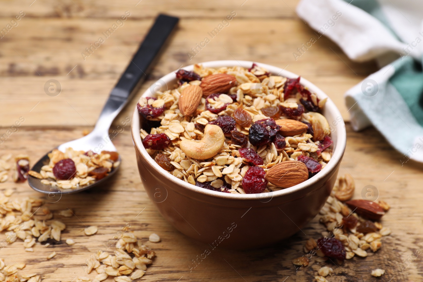 Photo of Tasty granola served with nuts and dry fruits on wooden table