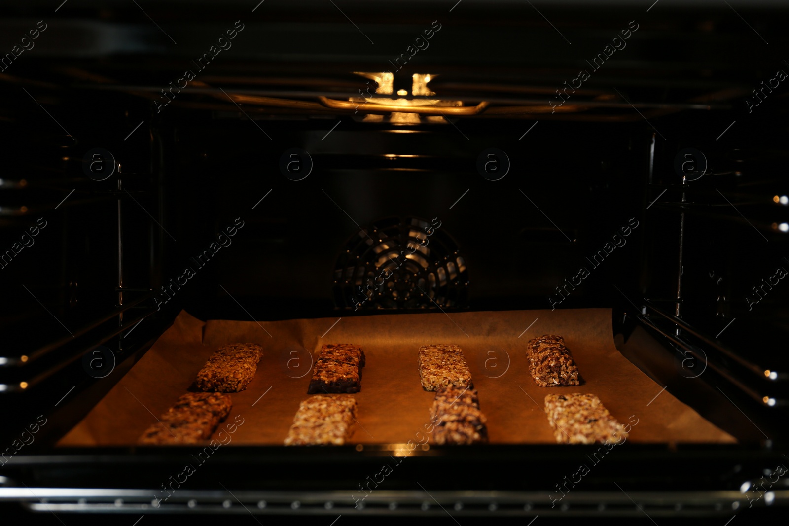 Photo of Delicious healthy granola bars on baking sheet in oven