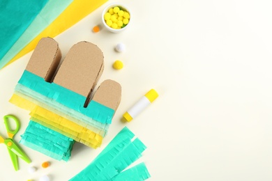 Photo of Cardboard cactus and materials on white background, flat lay. Pinata DIY