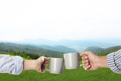 Closeness to nature. Couple with cups in mountains, closeup