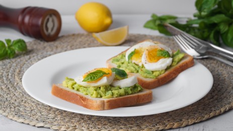 Photo of Tasty sandwiches with boiled egg, avocado and spinach on table, closeup