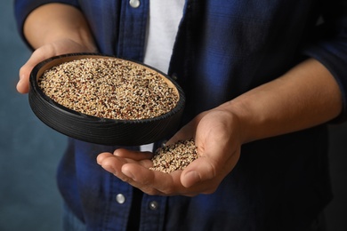 Photo of Woman holding plate with mixed quinoa seeds on color background, closeup