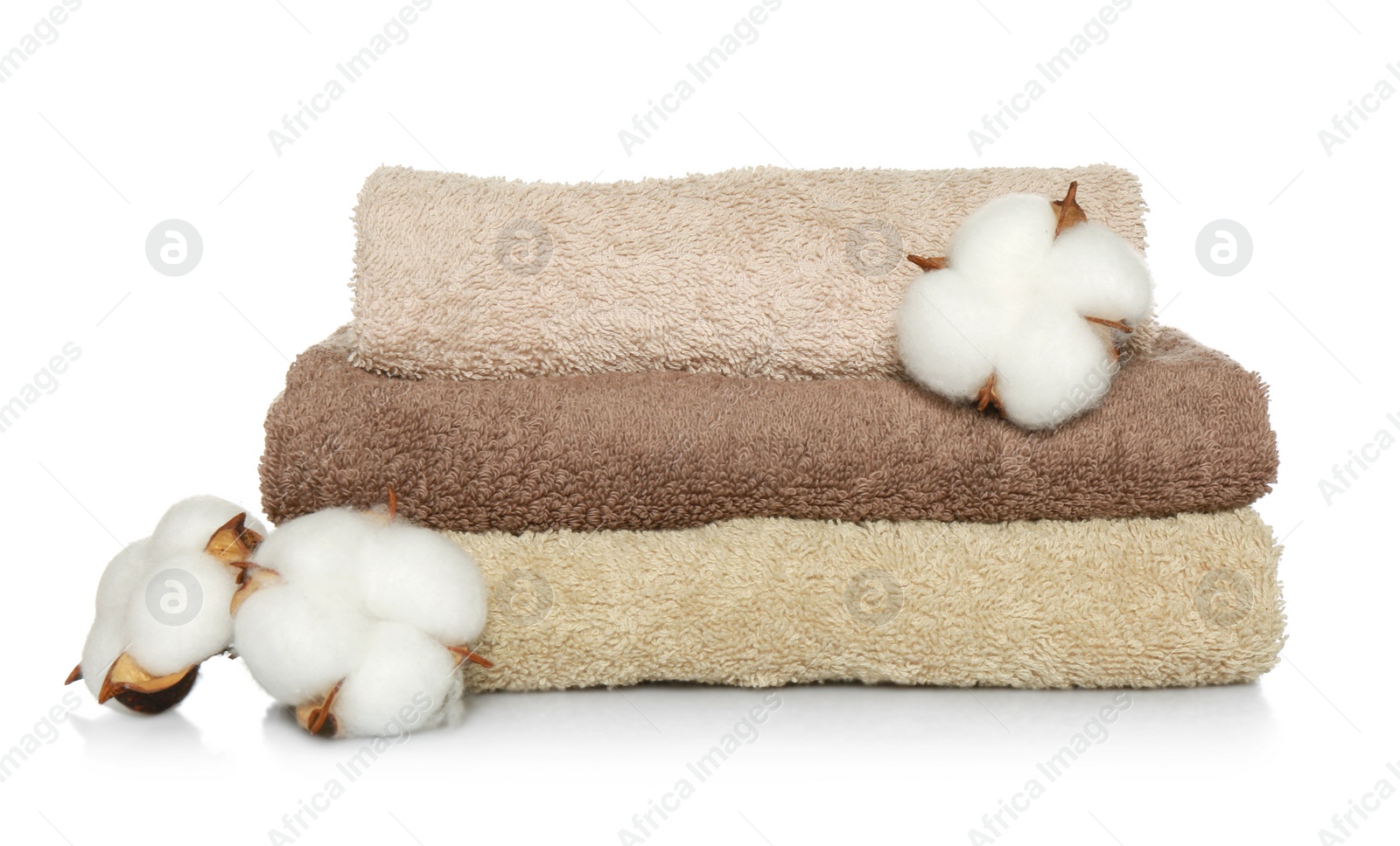 Photo of Folded soft terry towels and cotton flowers on white background