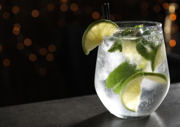 Glass of fresh alcoholic cocktail on bar counter, space for text