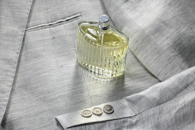 Photo of Luxury men's perfume in bottle on grey jacket