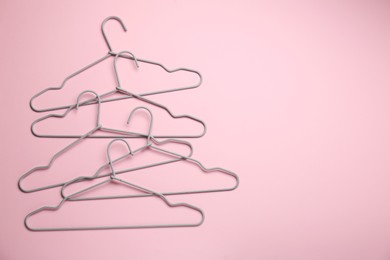 Photo of Hangers on pink background, flat lay. Space for text