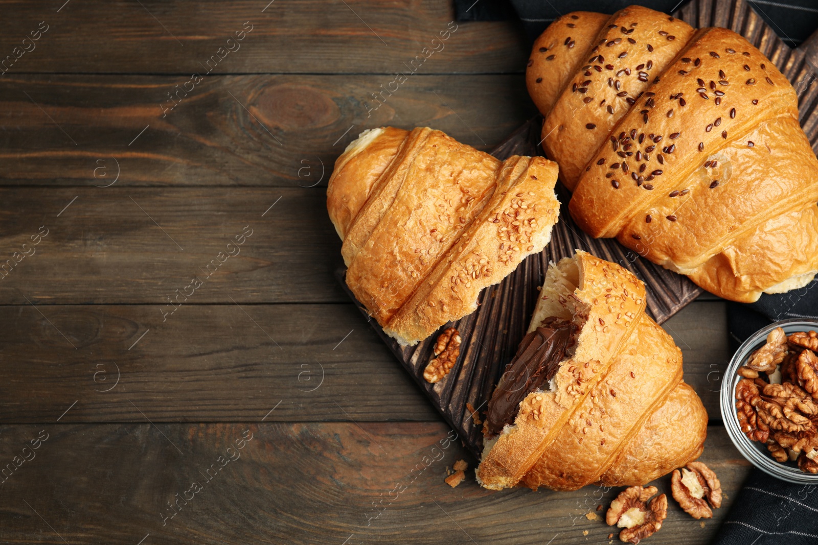 Photo of Flat lay composition with tasty croissants and walnuts on wooden table. Space for text