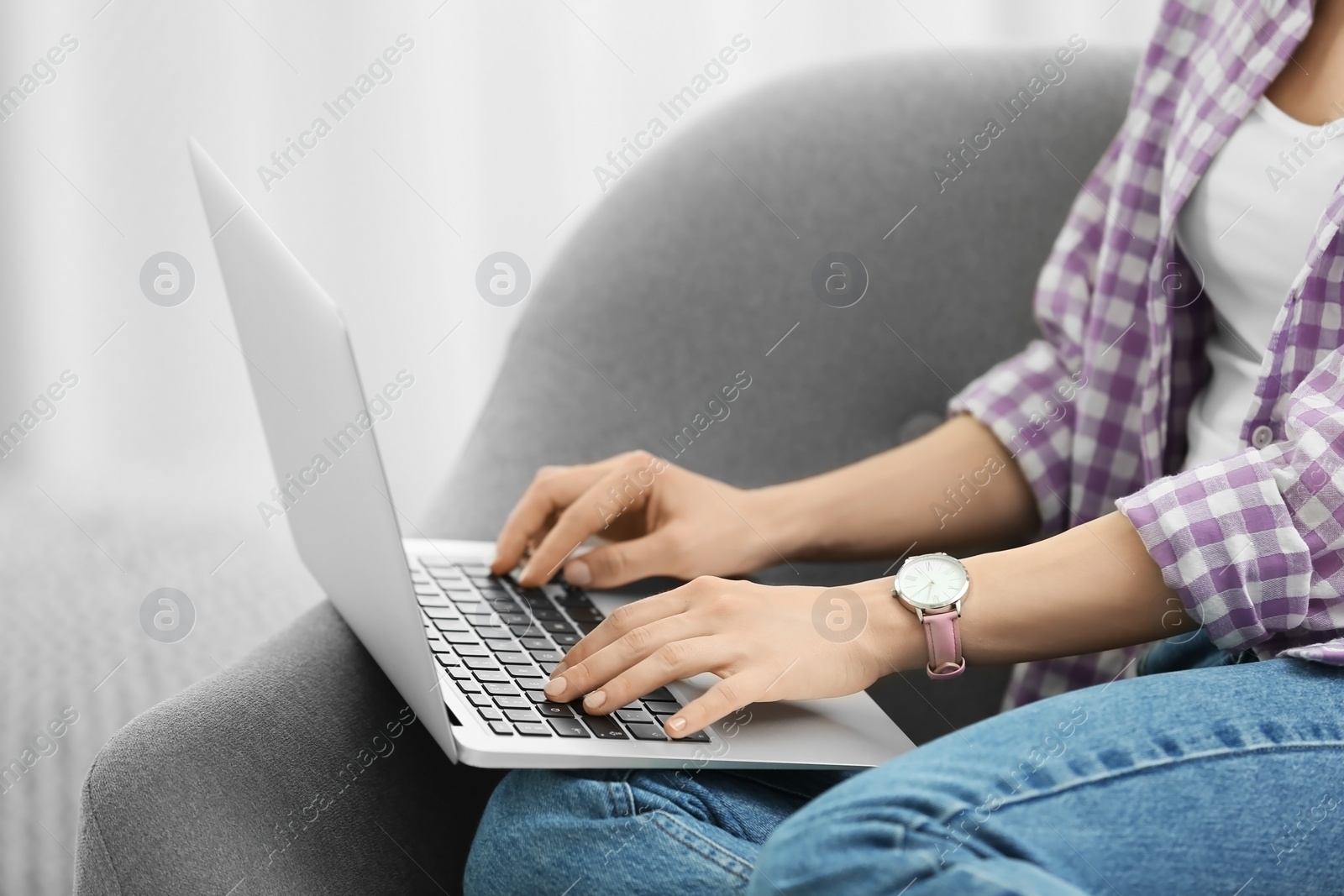 Photo of Young woman using laptop at home, closeup