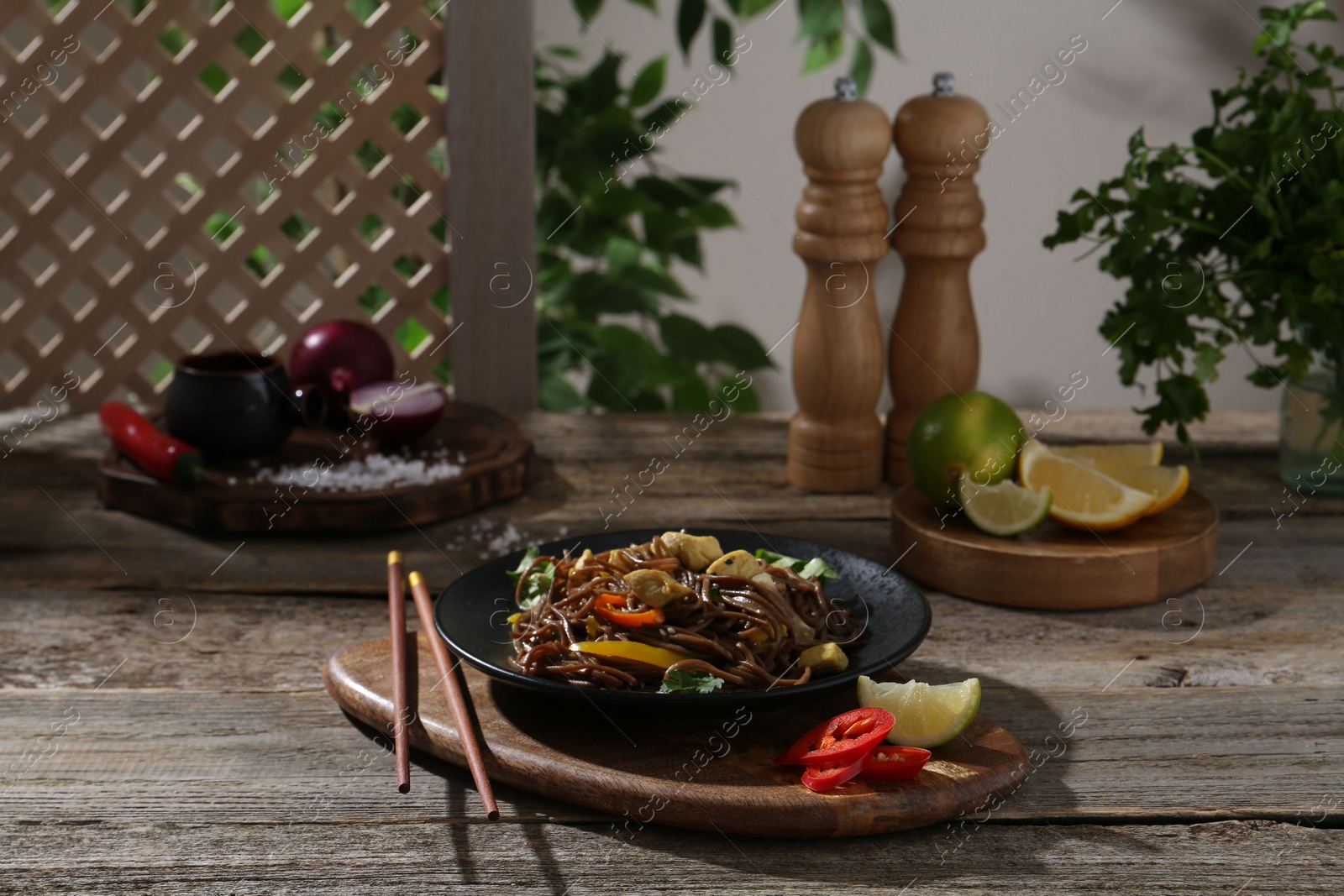 Photo of Stir-fry. Tasty noodles with meat and vegetables served on wooden table