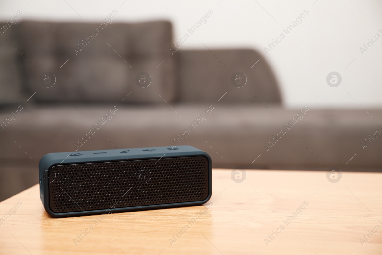 Photo of One black portable bluetooth speaker on wooden table indoors, space for text. Audio equipment