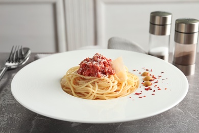 Photo of Plate with delicious pasta bolognese on table