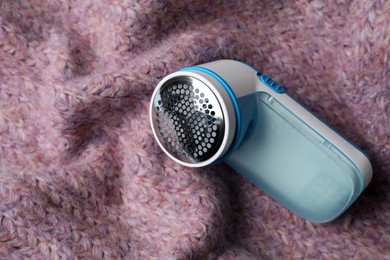 Modern fabric shaver on pink woolen sweater