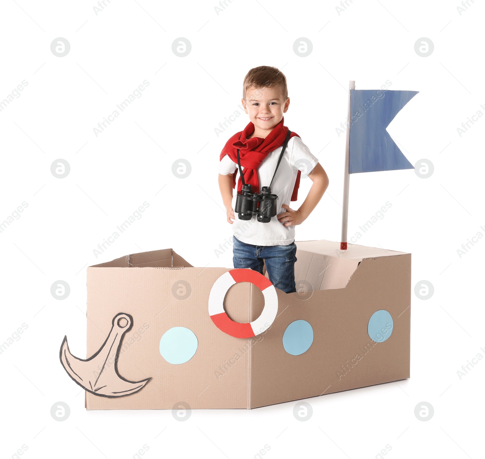 Photo of Cute little boy playing with cardboard ship on white background