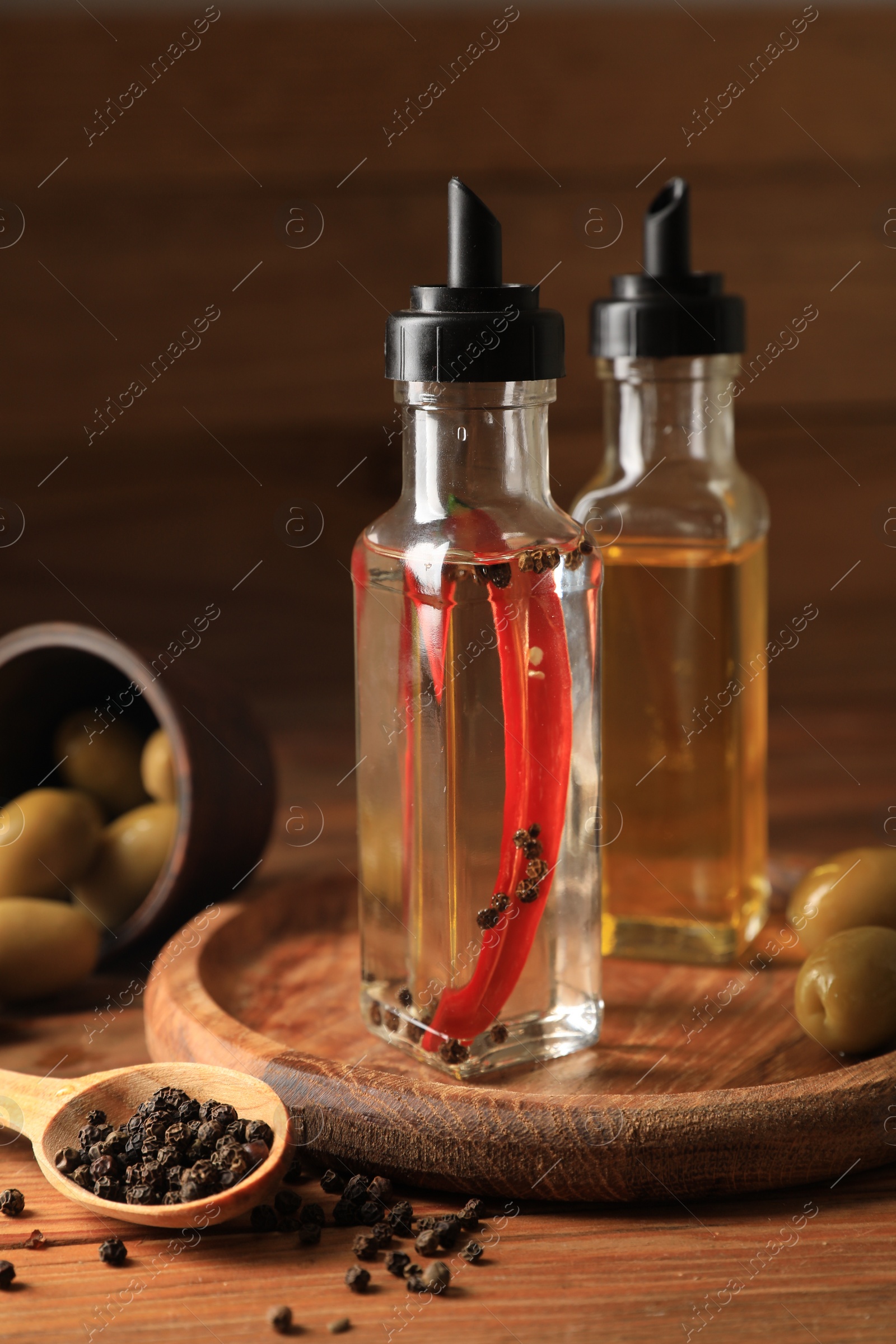 Photo of Different cooking oils and ingredients on wooden table