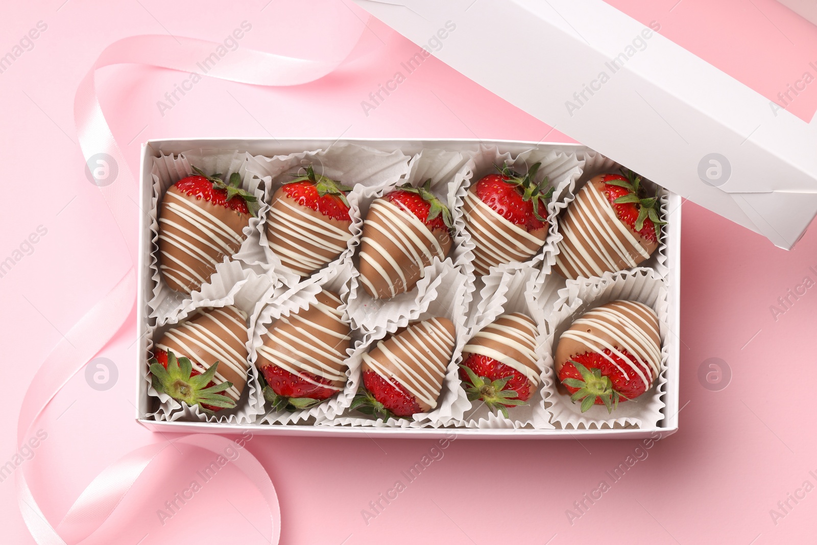 Photo of Box with delicious chocolate covered strawberries on pink background, top view