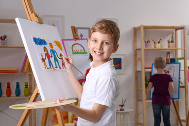 Photo of Cute little child painting during lesson in room