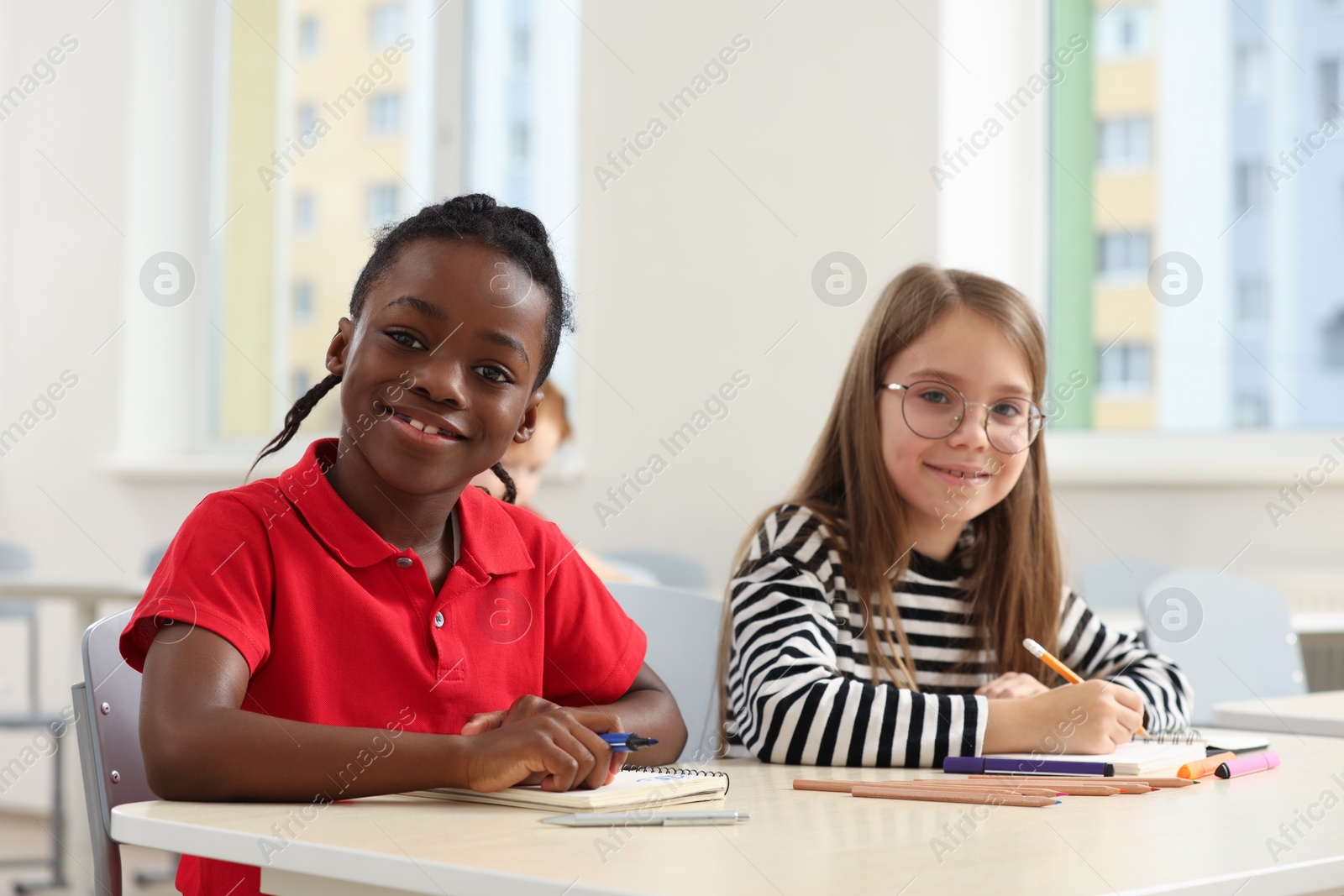 Photo of Cute children studying in classroom at school