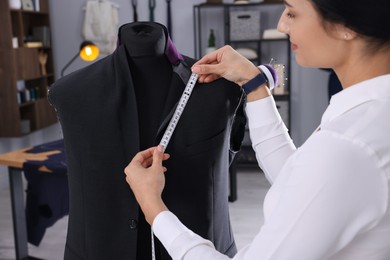 Professional dressmaker making suit jacket in atelier