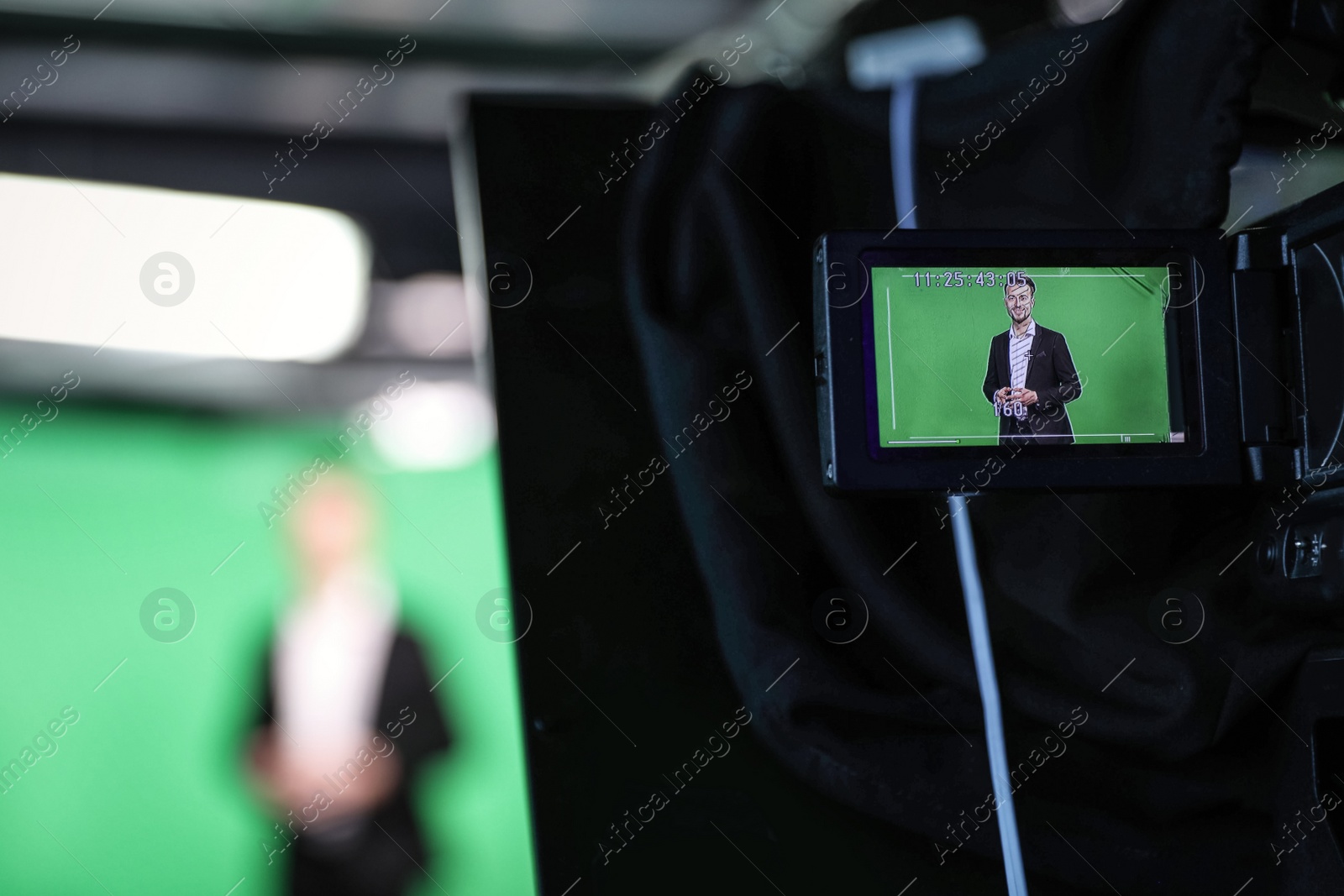 Photo of Presenter working in studio, focus on video camera screen