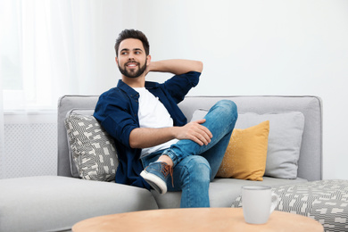 Photo of Young man relaxing on couch at home
