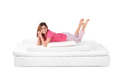 Woman lying on mattress pile against white background