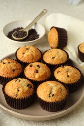 Photo of Delicious sweet muffins with chocolate chips on light textured table