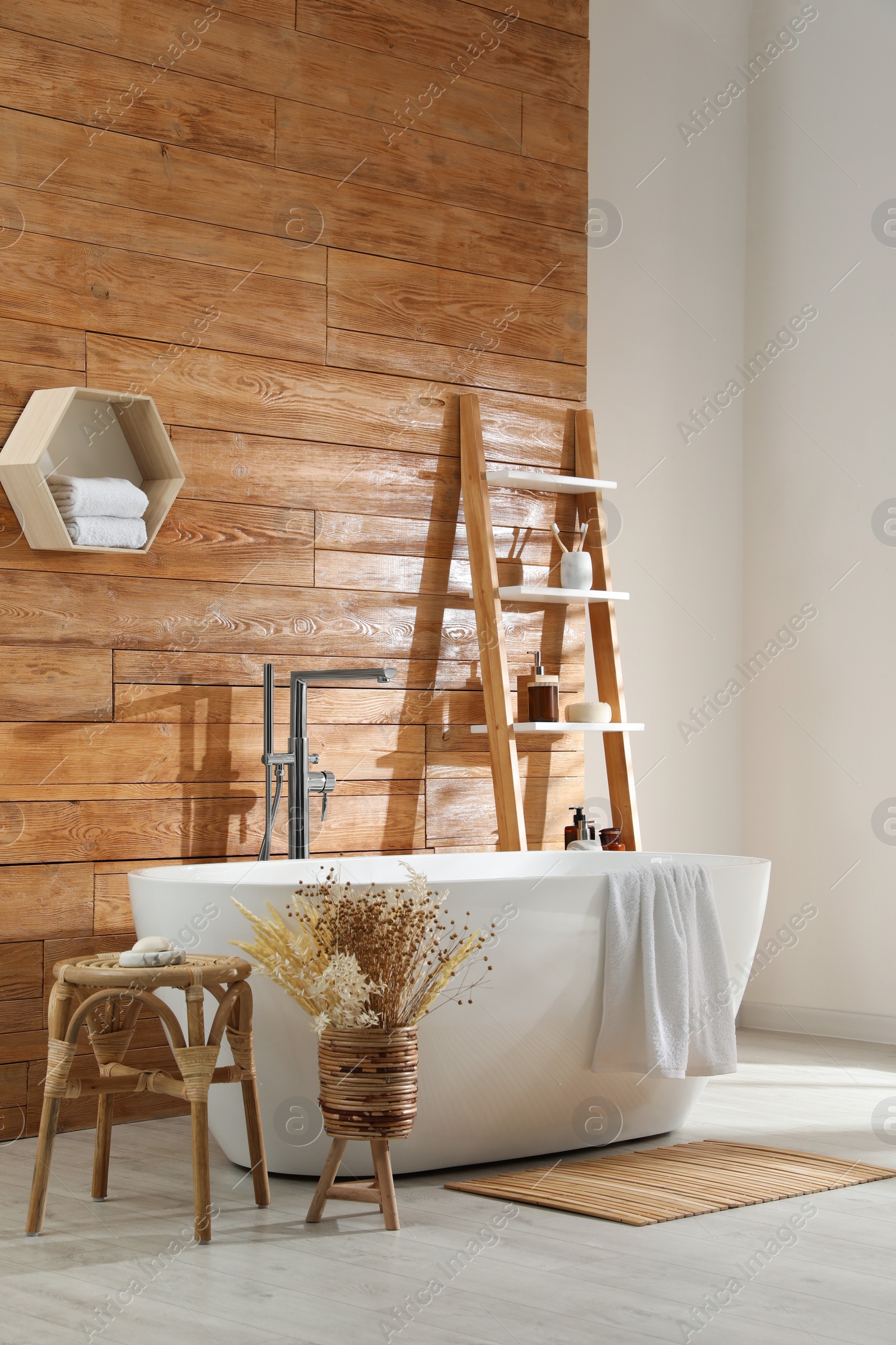 Photo of Bathroom interior with white tub and decor near wooden wall