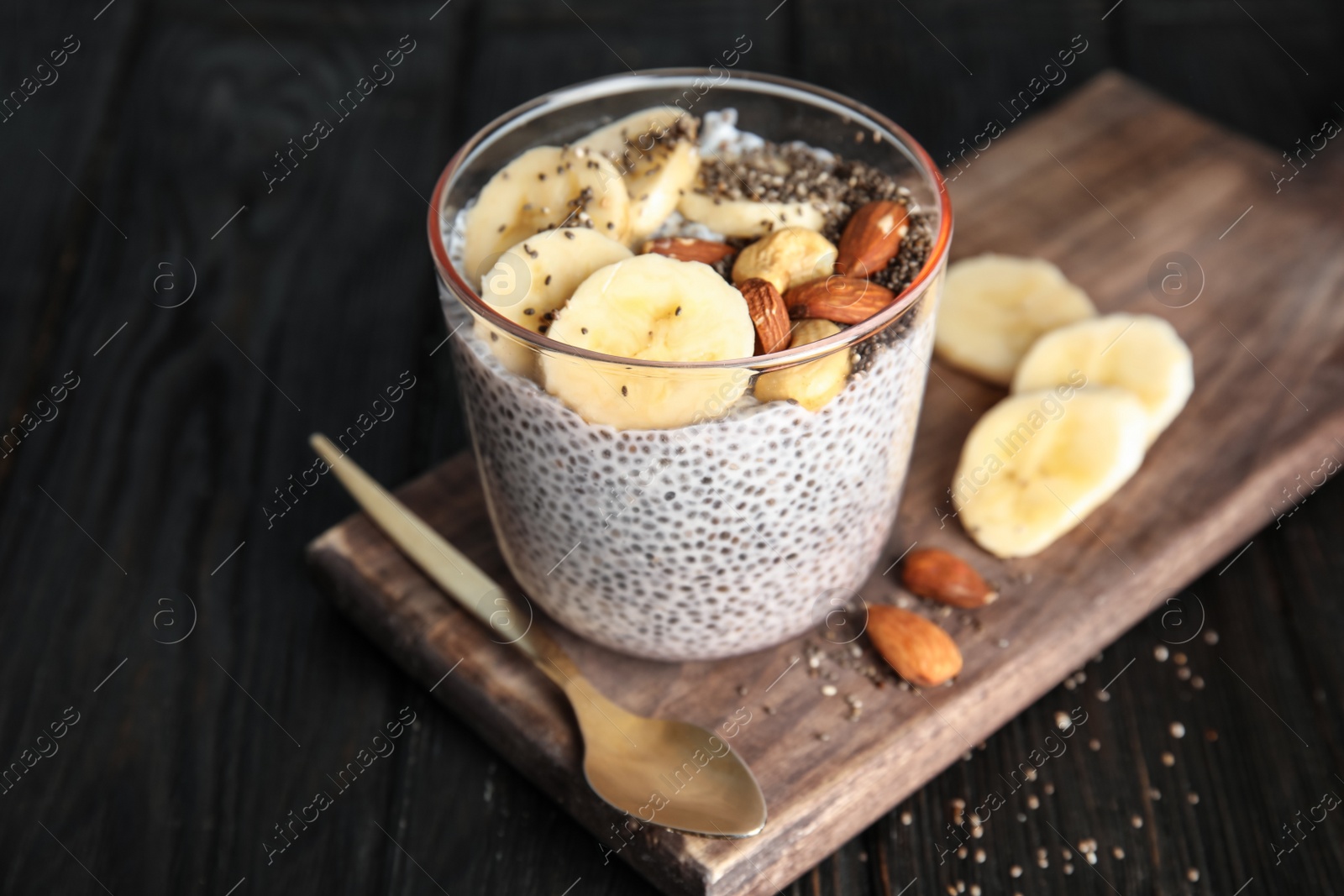 Photo of Dessert bowl of tasty chia seed pudding with banana and nuts served on table