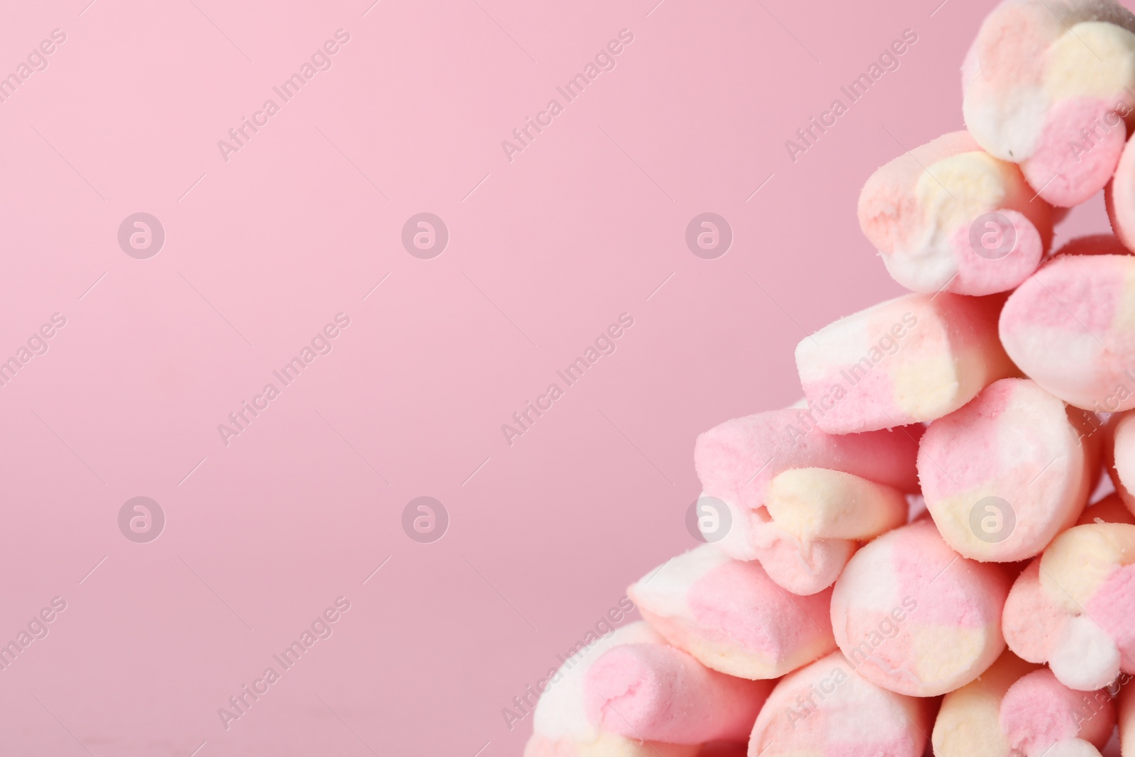 Photo of Stack of tasty marshmallows on pink background, closeup. Space for text